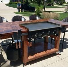 an outdoor bbq table with two grills on it