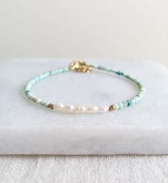 Beautiful Natural Turquoise beads and delicate Freshwater Pearls are used to create this modern boho beaded bracelet. D E T A I L S - Made with high quality Turquoise and Freshwater Pearl beads. - Five delicate Freshwater Pearls are centered among stunning natural Turquoise beads. - Non-tarnish 14k Gold-Filled chain adjuster. Gold-filled is a wonderful alternative to solid gold, and unlike gold plating, it is made to last a lifetime. - Lobster clasp closure. - Comes with a 1 inch adjuster. S I Z Turquoise Gemstone Beaded Bracelets For Beach, Turquoise Gemstone Beads Bracelet For Beach, Bohemian Pearl Bracelet With Colorful Beads And Adjustable Fit, Bohemian Adjustable Pearl Bracelet With Colorful Beads, Adjustable Bohemian Pearl Bracelet With Colorful Beads, Bohemian Turquoise Friendship Bracelets With Spacer Beads, Bohemian Gemstone Beads Friendship Bracelets For Beach, Bohemian Turquoise Beaded Bracelets With Tiny Beads, Dainty Turquoise Beaded Bracelets For Beach