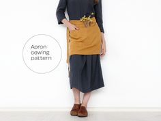 a woman standing in front of a white wall with an apron on her waist and the words apron sewing pattern below it