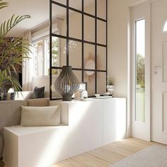 a living room filled with furniture and a large plant on top of a white shelf