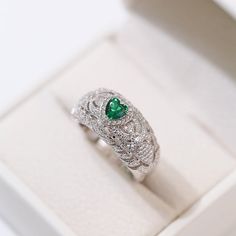 Featuring a heart-shaped emerald centerpiece surrounded by a dazzling halo of diamonds, this delicate ring embodies the essence of vintage elegance. The rich green color of emeralds symbolizes love and vitality, while sparkling diamonds add a touch of glamor. Metal: Recycled Sterling Silver Gemstone: Cubic Zirconia Ring Diameter: 10mm Weight: 7g Emerald And Diamond Ring, Edison Pearls, Vintage Elegance, Rich Green, Cubic Zirconia Rings, Vintage Heart, Emerald Gemstone, Delicate Rings, Recycled Sterling Silver