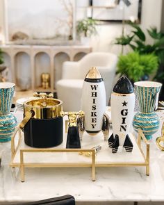 a table topped with vases and cups on top of a white marble countertop