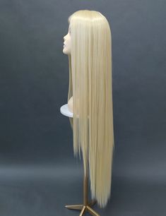 Lace part wig featuring a very long length and a fixed lace middle part. Inside cap has 3 combs and adjustable straps for a secure fit. Heat resistant (350F-400F degrees). Color: Light Blonde (613) Style: 40 inches, Straight Circumference: Default at 21" with adjustable cap (max 22"). Materials: Heat Resistant Synthetic Wig Fibers All sales are final. Please read all store policies before purchasing. Blonde Wig Costume, Rapunzel Wig, Long Blonde Wig, Long Blonde, Middle Parts, Middle Part, Blonde Wig, Light Blonde, Synthetic Wigs