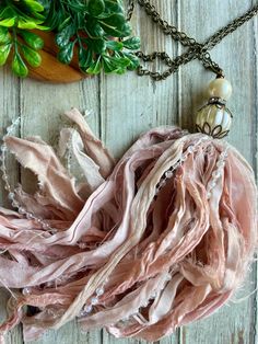 a pink scarf is laying on a wooden surface