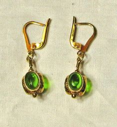 Excellent condition. Stamped 14K.  Pair weighs 5.7 grams. Total length of earrings is 1 1/2 inch, drop measures approx. 3/4 inch.  Three oval peridot cabochons on each earring that measure approx. 8 x 6.5mm. Yellow Gold Cabochon Drop Earrings, Formal Drop Cabochon Earrings, Classic Green Clip-on Earrings, Classic Green Clip-on Earrings For Formal Occasions, Formal Dangle Earrings With Cabochon, Elegant Green Jewelry With Lever Back Ear Wires, Elegant Green Cabochon Earrings, Elegant Pierced Peridot Jewelry, Elegant Oval Peridot Earrings