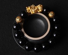 This Wealth and Luck Black Obsidian Pixiu Bracelet is a handmade item that features a 24k gold Piyao and two mantra beads, a mythical creature known for its ability to attract wealth and good luck. The bracelet is also crafted with genuine obsidian stones, a powerful gemstone believed to offer protection and grounding. Deatails: - Bracelet Design: 1 Piyao Charms + 2 Mantra Gold beads + 12 Black Obsidian Beads - Size:  (all size could be customized as you wish) Pixiu: 27.5*12.3*12.2 MM;  Mantra B Black Spiritual Bangle Jewelry, Spiritual Black Bangle Jewelry, Spiritual Black Bracelet With 108 Beads, Spiritual Black Beaded Bangle Bracelet, Black Spiritual Beaded Bracelets As Gift, Spiritual Black Beaded Bracelets As Gift, Black Beaded Bracelet Gift, Traditional Black Beaded Bracelets For Meditation, Black Crystal Bracelet With 8mm Beads