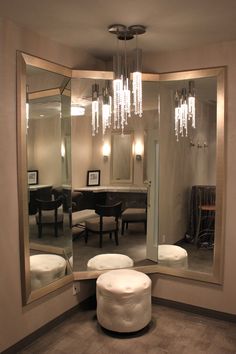 a large mirror sitting on the side of a wall next to a table and chairs