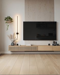 a flat screen tv mounted to the side of a wall next to a wooden shelf