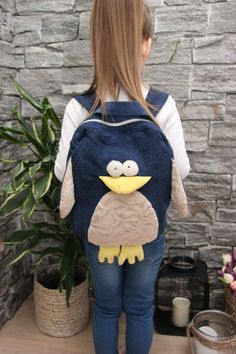 a girl is wearing a backpack with an angry bird on it's back pocket