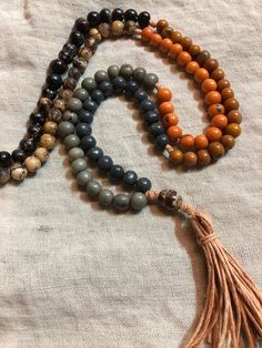 "This listing is for an acai seed bead mala necklace, 108 recycled and naturally dyed acai beads from Brazil and an oval guru salwag bead/palm bead from the Philippines.  The mala pictured is strung on organic hemp (peach/orange) with a handmade hemp tassel and knotted in 6 sections in 6 different colors (light grey, dark grey, tangerine, Sienna brown, dark natural, cream natural) each of an 18 count. 108 is a traditional spiritual number used in malas as a perfect derivative of 3, the number of Brown Spiritual Beads For Meditation, Artisan 108 Beads For Meditation, Spiritual Healing Brown Beads, Artisan Mala With Round Beads For Meditation, Brown Bohemian Mala With 108 Beads, Bohemian Brown Mala With 108 Beads, Spiritual Brown Mala For Healing, Artisan Beaded Mala For Meditation, Handmade Multicolor Spiritual Mala