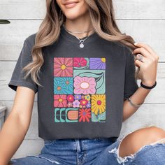 Add a touch of boho to your wardrobe with our Boho Flower T-Shirt. Featuring a beautiful floral design, this shirt will add a unique and playful touch to your style. Embrace your inner flower child and stand out from the crowd with this abstract yet stylish t-shirt. Hippie Multicolor T-shirt For Spring, Bohemian Spring T-shirt With Graphic Print, Trendy Multicolor Floral Print T-shirt, Multicolor Bohemian T-shirt For Spring, Casual Retro Print Top For Spring, Hippie Graphic Print Spring Top, Hippie Tops With Graphic Print For Spring, Hippie Style Graphic Print Spring Tops, Hippie Graphic Print Tops For Spring