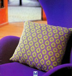 a purple chair with a yellow pillow on it