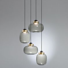 three white and gold colored glass pendant lights hanging from a ceiling fixture in a room