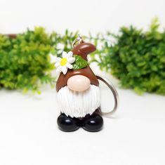 a brown and white gnome keychain with a flower in it's hair