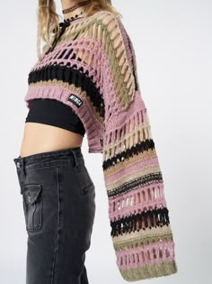 a woman in black jeans and a pink knitted sweater is standing with her back to the camera