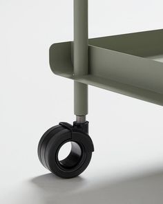 the wheels are attached to the side of a green table with two black bars on it