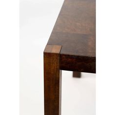 a close up of a wooden table on a white surface with no one around it