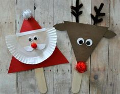 paper plate santa and reindeer puppets on wooden boards