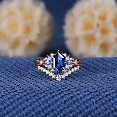 an engagement ring with a blue stone surrounded by white and brown diamonds on a blue blanket