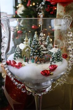 a wine glass filled with snow and christmas trees