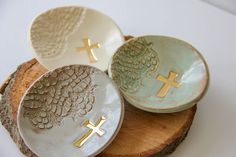 three plates with cross designs on them sitting on a piece of wood next to each other