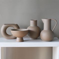 three vases and a bowl on a table