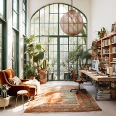 a living room filled with lots of plants and furniture next to a large arched window