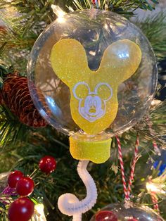 a mickey mouse ornament hanging from a christmas tree