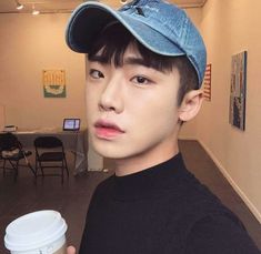 a young man holding a cup of coffee