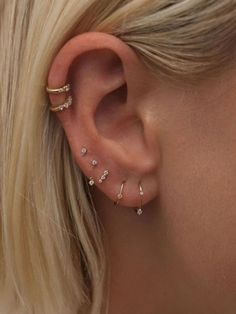 a close up of a woman's ear with three different types of piercings