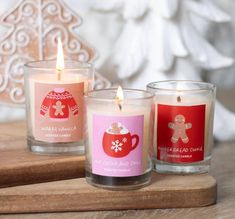 three candles sitting on top of a wooden tray