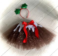 a brown and white tutu skirt with red bow on top, green holly berry headband