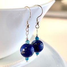 Beautiful and Unique. Handmade Lapis Lazuli with Faceted Apatite gemstone dangle drop earrings.  10mm Lapis Lazuli , 3mm Apatite.  Handmade with Solid Sterling Silver. Earth like.  Lightweight. Comes with meaning cards for each gemstone as seen in pictures. Returns or Exchanges accepted within 30 days of purchase.Feel free to message me with any questions you may have, I'm happy to answer them. Chip Bead Jewelry, Gold Round Earrings, Lapis Jewelry, Earrings Ideas, Gemstone Drop Earrings, Turquoise Crystal, Gemstone Beaded Necklace, With Meaning, Blue Gemstones