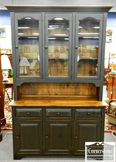 an antique china cabinet with glass doors and drawers