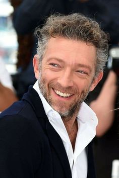 a smiling man with grey hair and white shirt