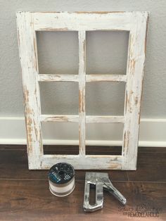 an old window frame is sitting on the floor next to a tape dispenser