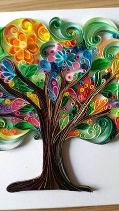 a colorful tree made out of paper on top of a wooden table