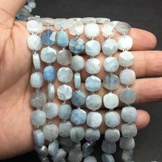 a hand is holding several blue and white beads