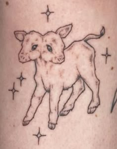 a small tattoo of a baby lamb on the leg, with stars in the background