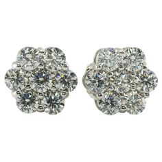 Diamond Earrings Studs 14K White Gold Cluster 1.12 TDW This pair of diamond cluster studs is crafted in solid 14K White Gold. There are seven natural round brilliant cut diamonds totaling 1.12 carats for the pair. The diamonds are VS2-SI1 clarity and HI color. The earrings are equipped with long posts and butterfly backings. The top of the earrings measures 9mm. The earrings weigh 2.7 grams. Great estate condition. Dazzling Cluster Diamond Earrings For Formal Occasions, Dazzling Cluster Diamond Earrings For Formal Events, Round Platinum Cluster Earrings With Diamond Cut, Platinum Cluster Diamond Earrings For Formal Occasions, Luxury Cluster Diamond Earrings With Single Cut Diamonds, Dazzling Diamond White Cluster Earrings, Classic Platinum Cluster Earrings With Vvs Clarity, Luxury Cluster Diamond Earrings For Anniversary, Diamond Cluster Earrings For Anniversary