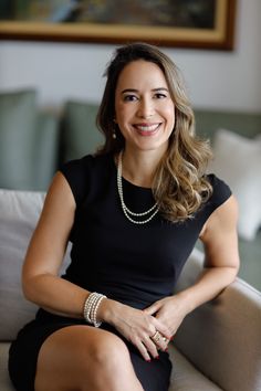 a woman sitting on top of a couch smiling