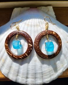 These coconut shell hoop earrings feature a Caribbean blue glass piece made on the island of Java. They are hand wrapped with 14 kt gold filled wire and hang from 14 kt gold filled ear hooks. Coconut shell hoop is 1.5 inches in diameter and the glass piece is approximately 1 cm at widest point.  Due to the natural nature of the coconut shell and handmade nature of the glass, each earring set will vary slightly in size, color, shape, and thickness. Each pair is completely unique. Every purchase r Blue Hoop Jewelry For The Beach, Blue Small Hoop Jewelry For Beach, Blue Small Hoop Jewelry For The Beach, Handmade Small Hoop Jewelry For Vacation, Handmade Small Hoop Earrings For Vacation, Beach Hoop Earrings Wire Wrapped, Beach Wire Wrapped Hoop Earrings, Beach Hoop Earrings With Wire Wrapping, Beach Earrings With Recycled Glass And Ear Wire