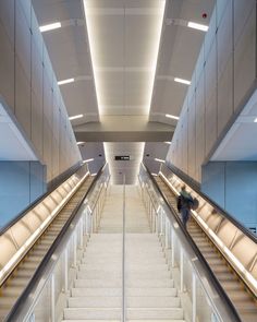 an escalator leading up to the second floor in a building with white carpeting