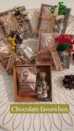 several small bottles with flowers in them on a table next to pine cones and twine