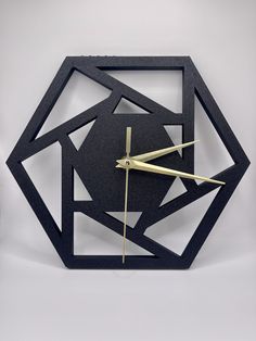 a clock made out of black paper with gold hands and an abstract design on the face