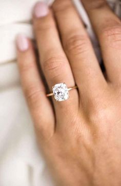 a woman's hand with a diamond ring on it