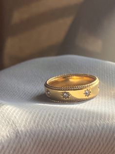 a gold wedding band with three diamonds on it