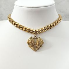 Our chunky gothic heart choker is beautifully handmade with a real premium feel. This stunning choker is available in a choice of two shades made with a detailed heart pendant accompanied by a gorgeous chunky chain. Chain type on silver and gold versions vary. Chain length is with a 28cm with 5cm extender. Chain thickness is 7mm. Silver colour material is pure stainless steel. Gold colour material is stainless steel with 14k gold plating. Gothic Heart Choker For Valentine's Day, Gothic Heart-shaped Choker For Valentine's Day, Vintage Heart Charm Choker Jewelry, Vintage Heart Charm Choker, Metal Choker With Heart Charm And Pendant, Gothic Heart Charm Choker Jewelry, Gothic Heart-shaped Choker For Gift, Metal Heart Pendant Choker With Heart Charm, Metal Heart Charm Choker With Heart Pendant