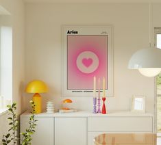 a living room with white furniture and art on the wall