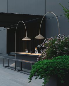 two lamps sitting next to each other on top of a wooden table in front of a building